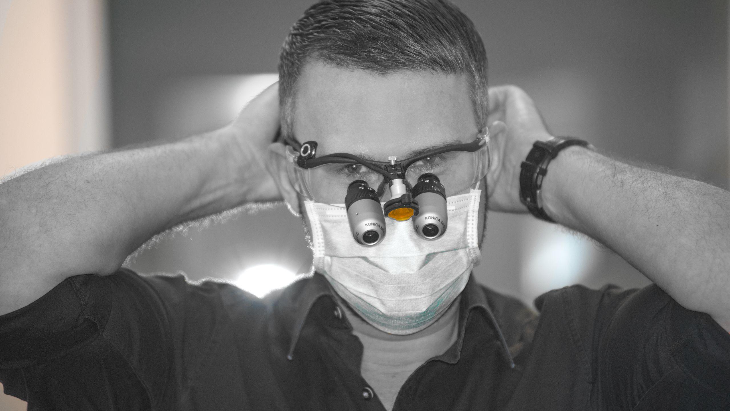 Ein Schwarz-Weiss Foto von einem Zahnarzt der sich auf eine Behandlung vorbereitet